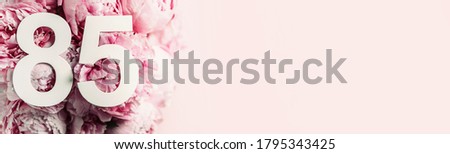Peony flowers, digit eighty-five. Birthday greeting card with inscription 85. Anniversary concept. Top view. White numeral on flower background. Numerical digit, Celebration event, template, flyer. Royalty-Free Stock Photo #1795343425