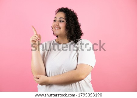 Young beautiful woman standing over isolated pink background smiling happy pointing with hand and finger to the side