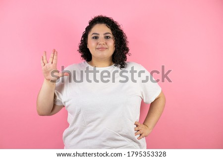 Young beautiful woman over isolated pink background doing hand symbol