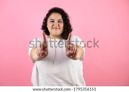 Young woman over pink isolated background saying no with fingers, angry and frustration expression