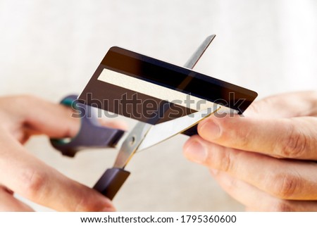caucasian male person cutting his credit card. close up. bankruptcy concept. financial problems concept.