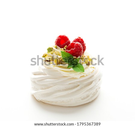 Pavlova dessert cake with cream and fresh raspberries on a white background, close-up