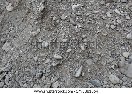 Various number of different sized and shaped stones lie around  the  on the ground in sunny and summer time Close up.
