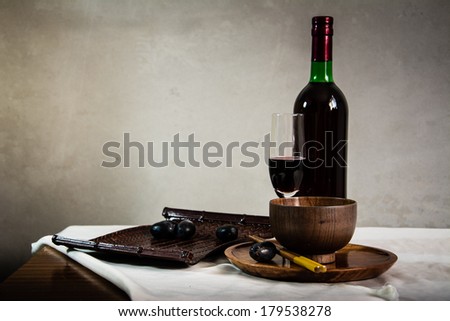Still life Photography with Old red wine on wooden table and blue grunge background 