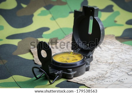 Military compass and map on a camouflage background