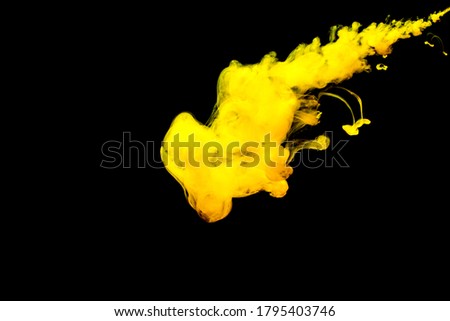 A cloud of yellow paint released into clear water. Isolate on a black background.