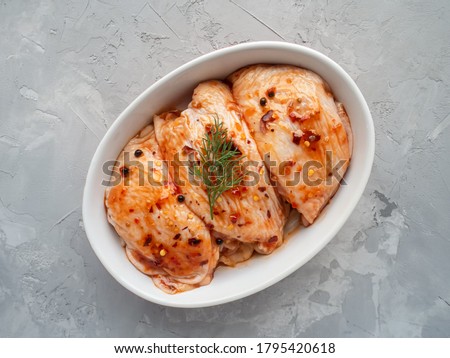 Raw marinated hen thighs for grill and bbq. Cooking meat. Raw spiced chicken thigh and marinade ingredients before cooking . Royalty-Free Stock Photo #1795420618