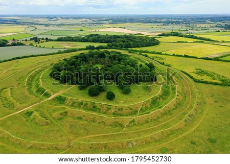 Aerial view of Badbury Rings in Dorset, United Kingdom. A historic Iron Age hill fort in east Dorset, England, which dates from around 800 BC and was in use until the Roman occupation of 43AD. Royalty-Free Stock Photo #1795452730