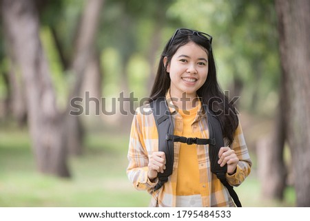 Portrait Asian young woman hiker hiking in forest standing with backpack.