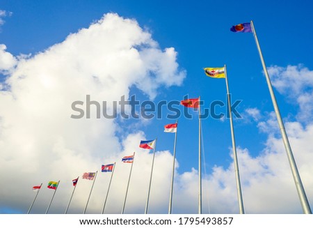 ASEAN flags and the member nations flags on blue sky and white cloud. Royalty-Free Stock Photo #1795493857