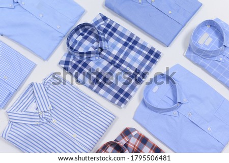 folded o new blue man's,striped  shirt and two plaid, long sleeve shirt on whit background