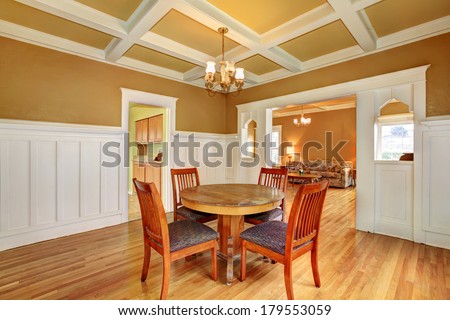 Bright dining room with a coffered yellow and white ceiling, hardwood floor. View of the living room