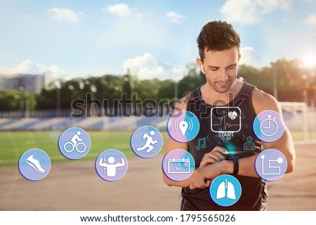 Man using smart watch during training outdoors. Icons near hand with device Royalty-Free Stock Photo #1795565026