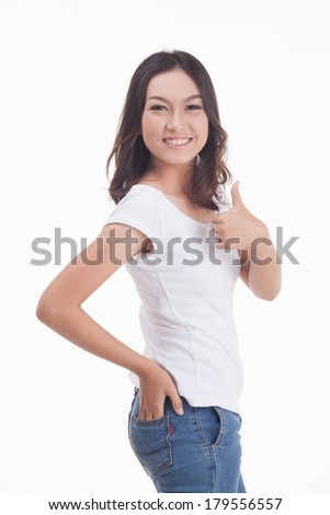 Beautiful Asian girl in jeans and white t-shirt smiling and giving a thumbs up on a white background.