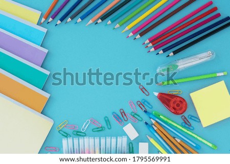 Top view of school supplies lie on light blue background. Back to school concept. 