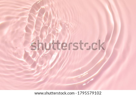 Closeup of pink transparent clear calm water surface texture with splashes and bubbles. Trendy abstract summer nature background. Coral colored waves in sunlight. Royalty-Free Stock Photo #1795579102