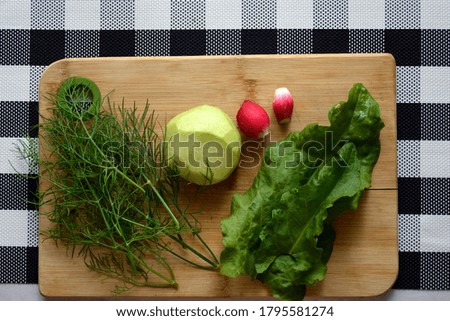 Vegetables are on the cutting Board. ingredients for vitamin salad on a checkered background.