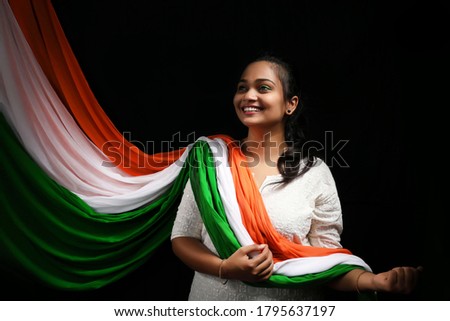 Independence Day (15 august) - happy Indian women in indian attire with  national Indian flag, wearing tricolor cloths and mask on. Royalty-Free Stock Photo #1795637197