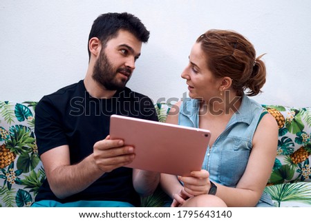 Couple choosing a holiday destination using a tablet. Concept of a holiday for two