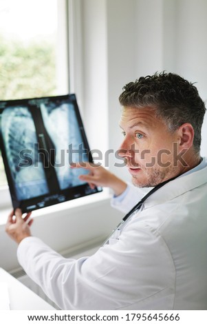Doctor discusses X-ray image via video conference with his patient