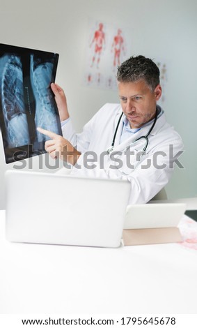 Doctor discusses X-ray image via video conference with his patient