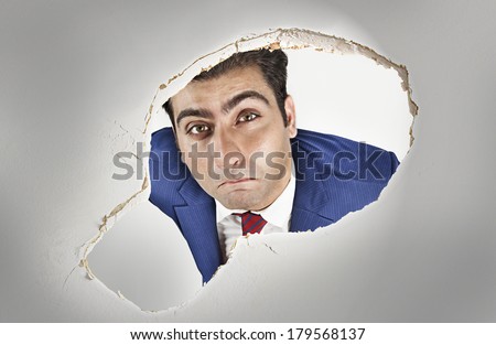 Man looking through a hole in the ceiling 