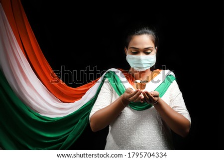 Independence Day (15 august) - happy Indian women in Indian attire with  national Indian flag, wearing tricolor cloths and mask on.
