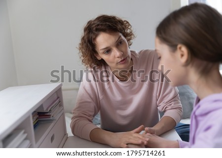 Caring mother supporting upset teenage daughter, holding hands, talking, discussing problems, sharing secrets, trusted family relationship concept, loving mum comforting sad teenager girl Royalty-Free Stock Photo #1795714261