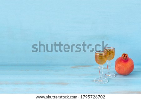 Wine and pomegranate for Jewish holiday Rosh hashana on blue wooden background with copy space.