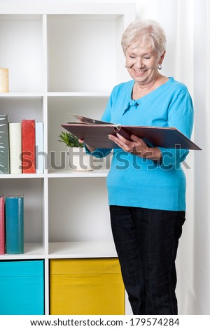 Senior lady viewing family album at home
