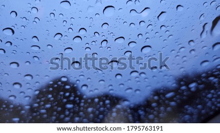 Rain drops on the windshield, with natural as a backdrop, look fresh, for background and text.