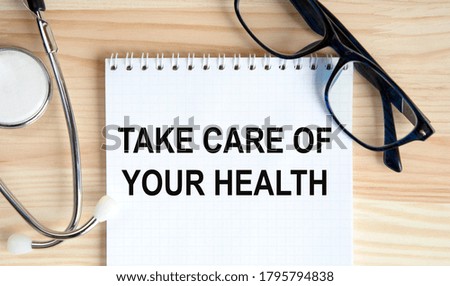 Take care of your health. The inscription is made in a notebook, next to a notebook tablet and stethoscope.