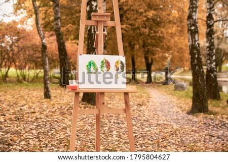 autumn picture in the park on an art easel