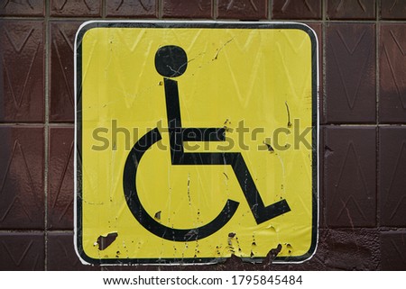 Yellow wheelchair sign on the wall  
