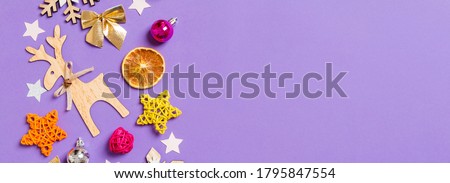 Top view Banner of New Year toys and decorations on purple background. Christmas time concept with empty space for your design.