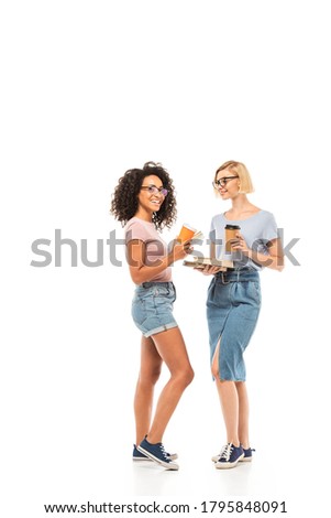 Multiethnic students with disposable cups and books on white background