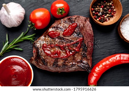 
Grilled beef monster steak with spices for halloween on stone background