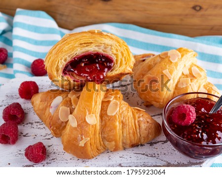 Yummy freshly croissant, with raspberries jam filling cut, close up Royalty-Free Stock Photo #1795923064