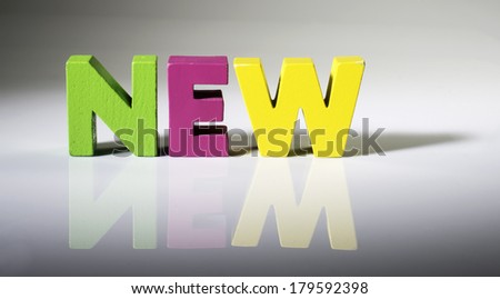 Multicolored text new made of wood. White background