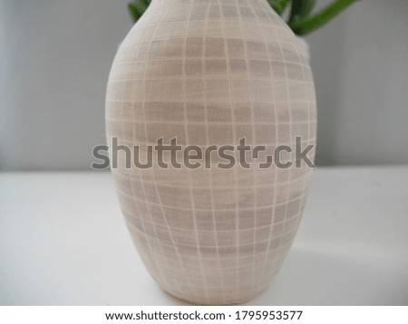 Gray vase in a cage on the table, close-up