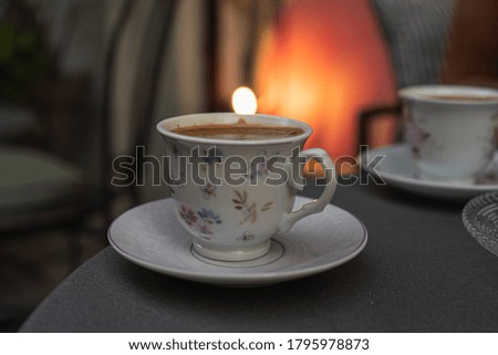 A closeup shot of floral cups of Eastern coffee on a gray table