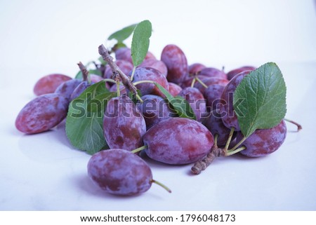 Macro photo food fruit plum on a white background. Texture background of fresh blue plums. Pictures fruit food blue plums