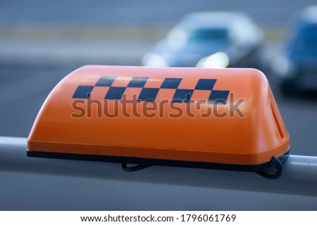 Orange sign of a taxi on the background of a car
