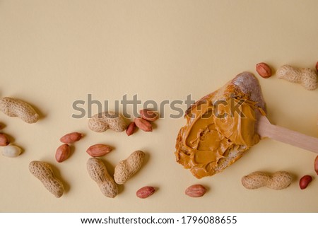 Peanut butter on bread, peanut sandwich scattered on the table. Colored background. Copy space for your text