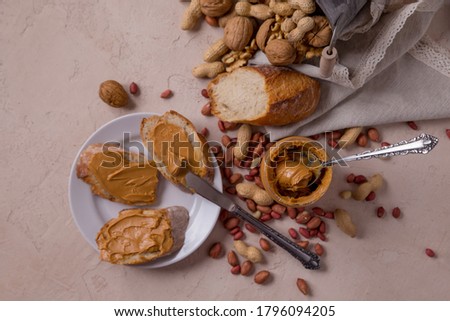 Peanut butter on bread and in a jar, peanut sandwich, nuts scattered on the table. walnuts.