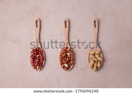 different varieties of peanuts on a light background. whole and peeled nuts