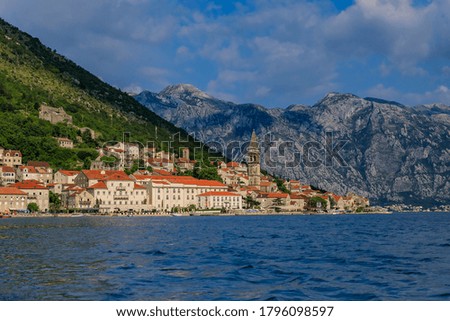 Scenic panorama view of the historic town of Perast located at world-famous Bay of Kotor on a sunny day with mountains in the background, Montenegro