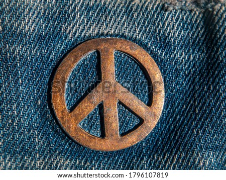 Iron sign of a pacifist on denim. The symbol of the struggle for peace. Ideology. Place for your text. Background image. Denim clothing.