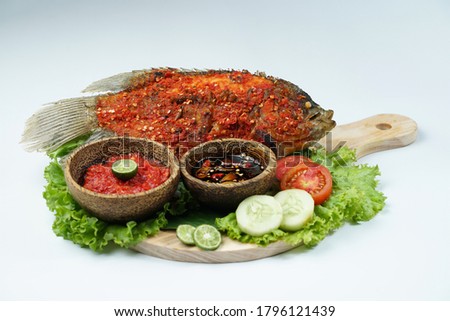 Fried fish sprinkled with hot chili sauce on isolated white background. Usually used for menu list pictures or food pictures in restaurants. Top view