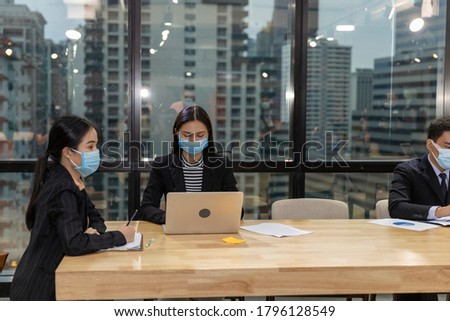 Business in new normal. Office workers wearing face mask and protection while having internal meeting for new business strategy or plan. Technology for new normal